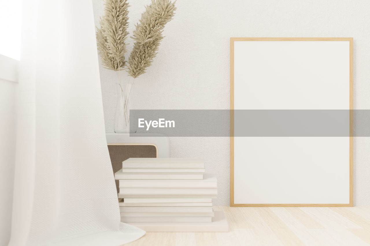 EMPTY CHAIR AGAINST WHITE WALL AT HOME