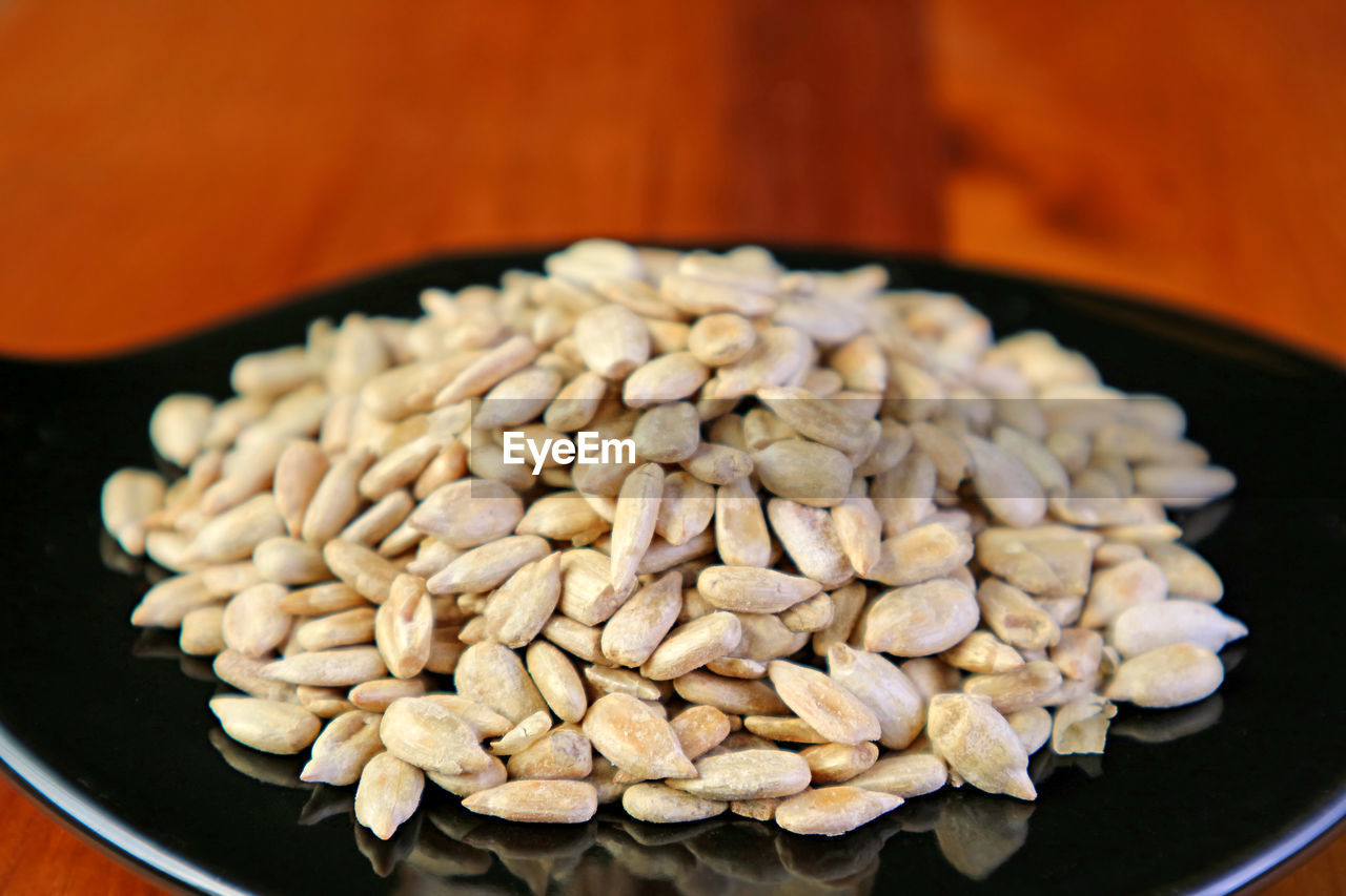 Closeup pile of roasted sunflower seeds in a black saucer