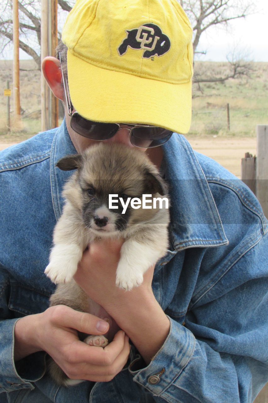 Teenage boy carrying pembroke welsh corgi puppy