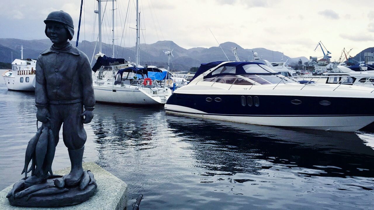 MAN ON BOAT MOORED AT HARBOR