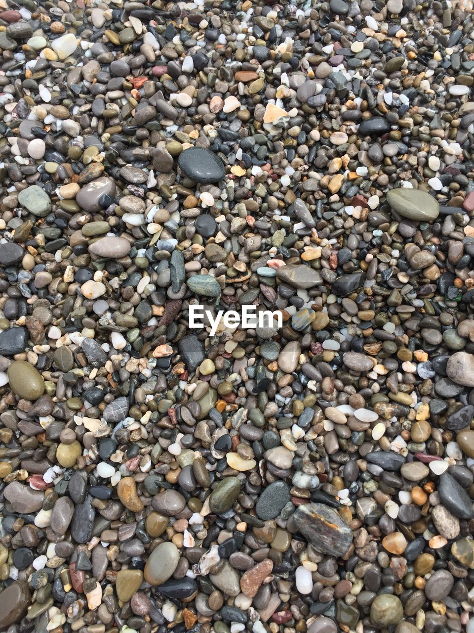 CLOSE-UP OF PEBBLES ON BEACH