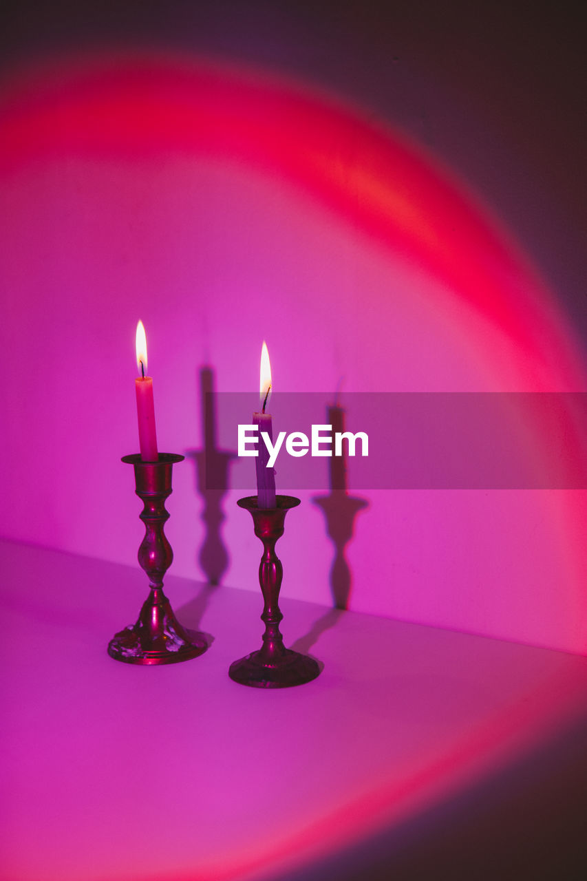 Close-up of illuminated candles on table