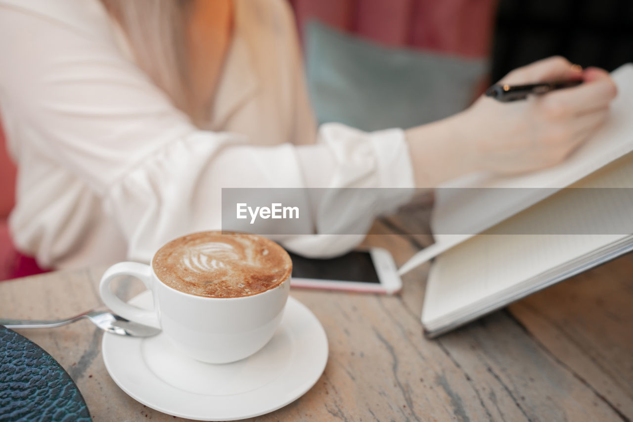 Midsection of coffee cup on table