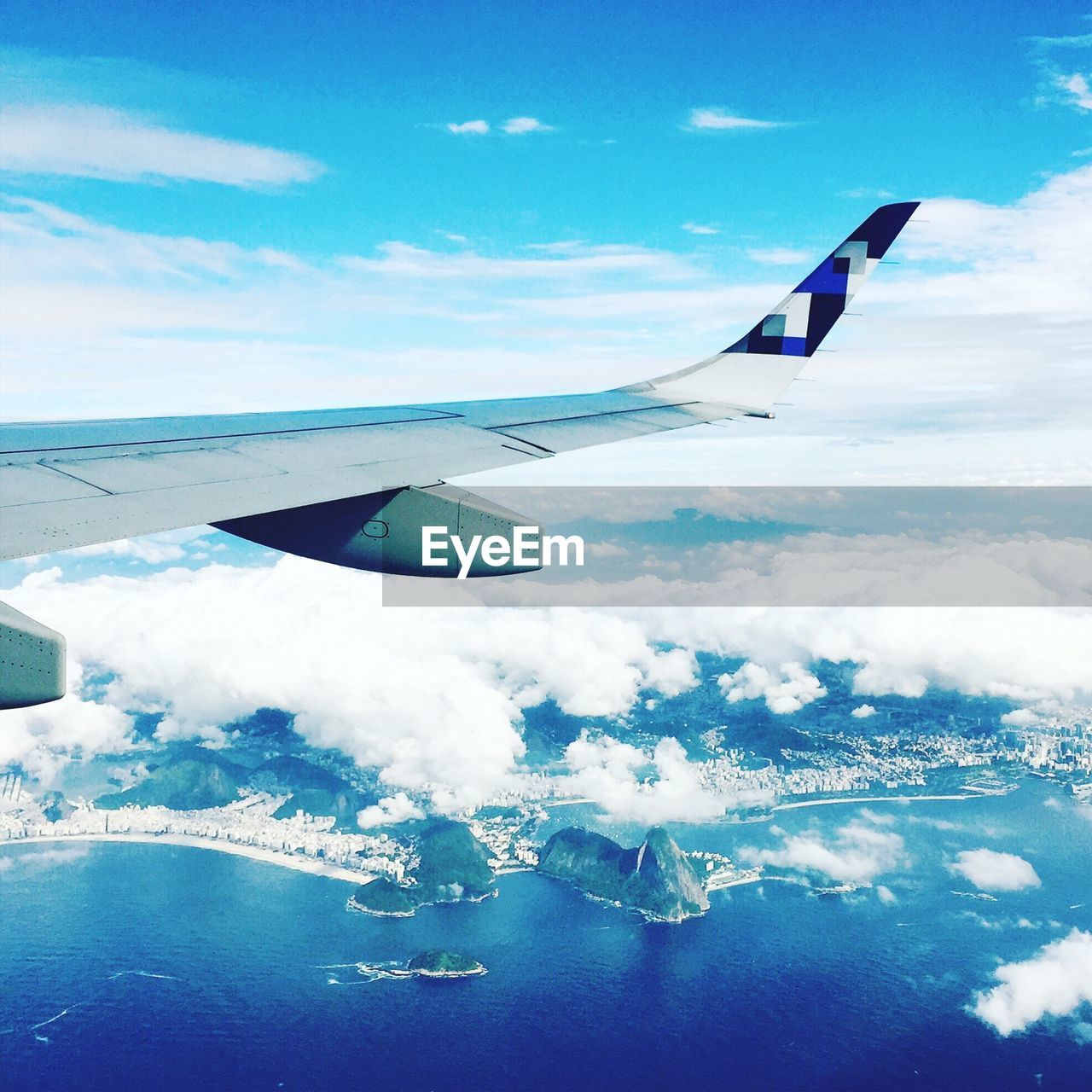 AERIAL VIEW OF AIRPLANE WING FLYING OVER CLOUDS