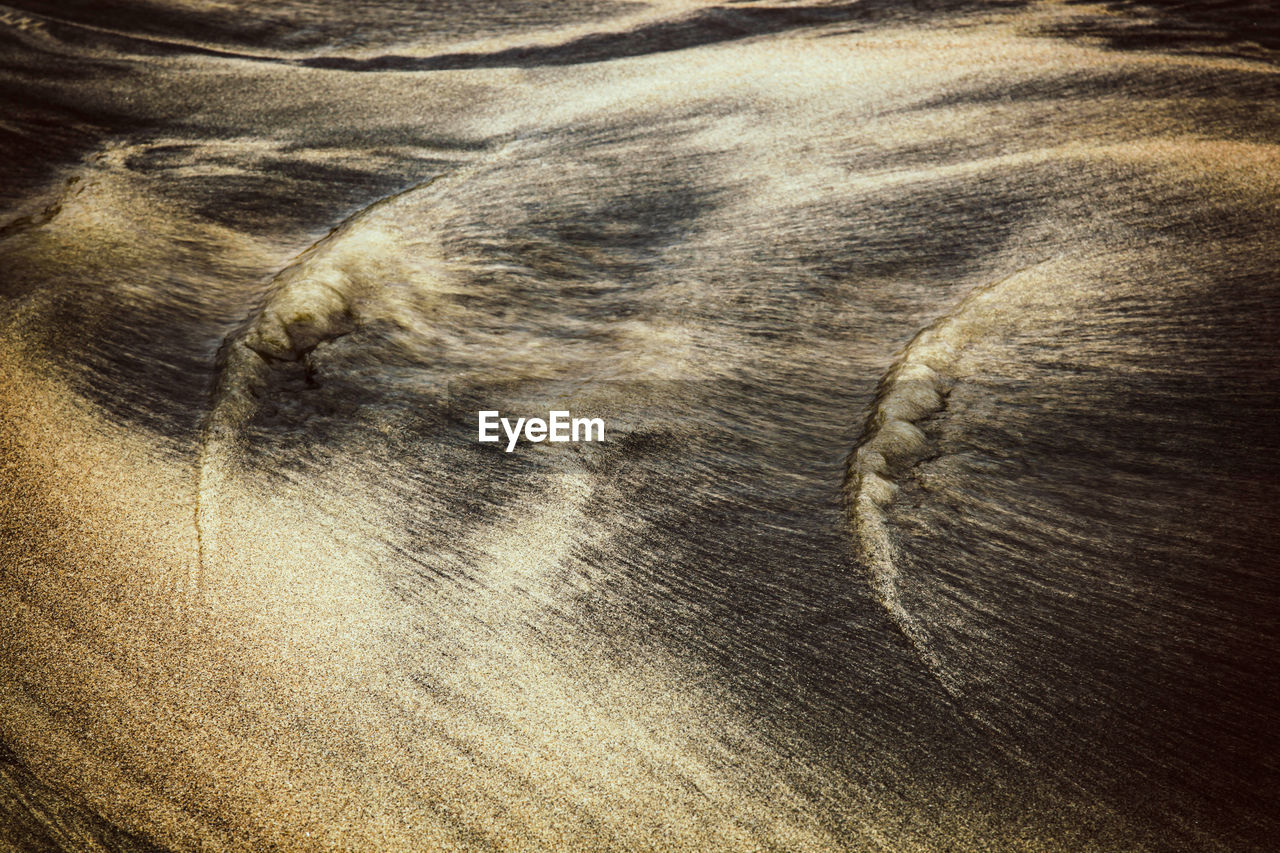 Abstract background with texture and pattern of sand with streaks and veins.