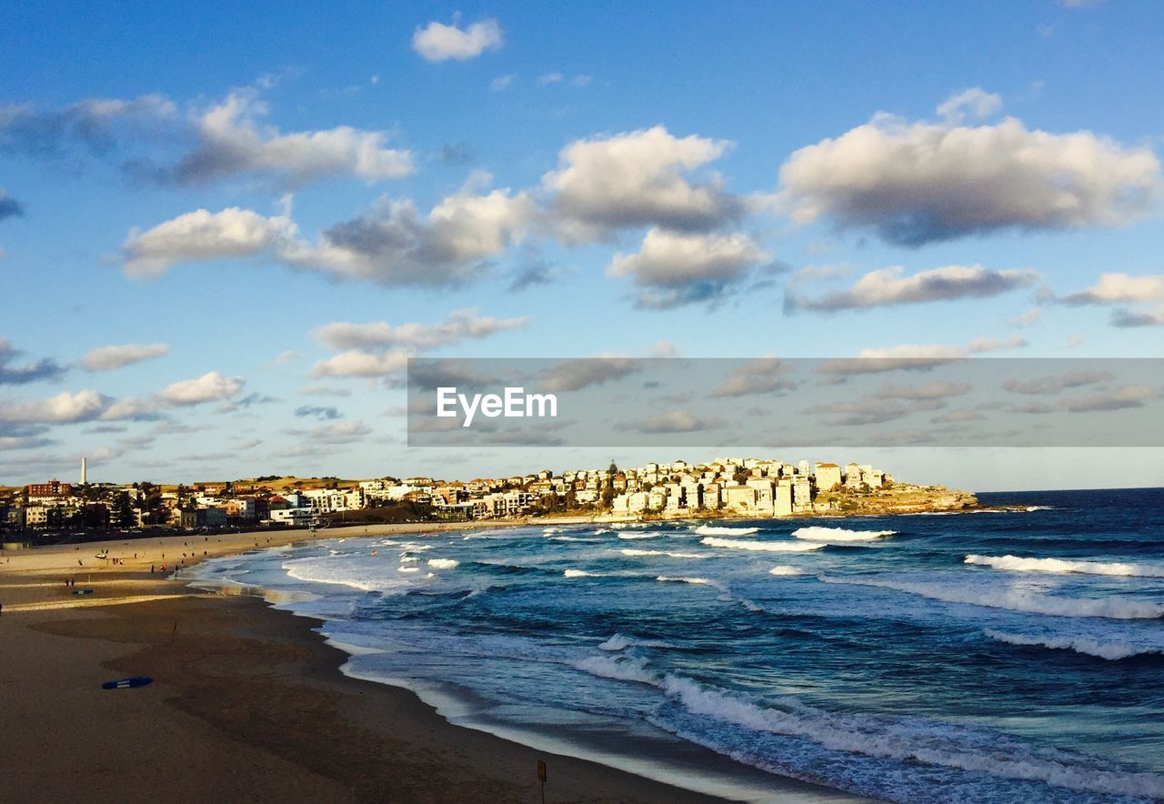 VIEW OF BEACH WITH CITY IN BACKGROUND