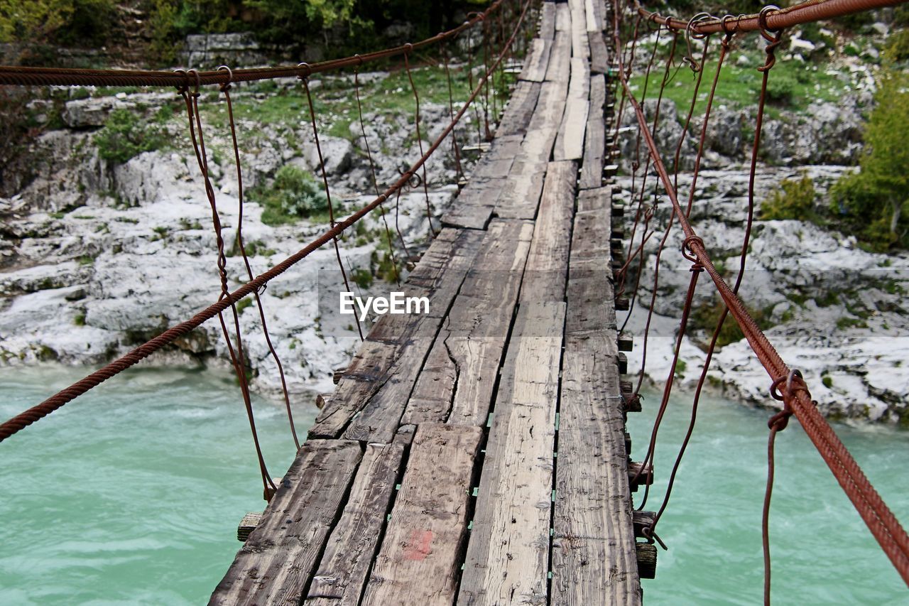 rope bridge, water, tree, nature, rope, wood, bridge, plant, suspension bridge, day, no people, land, tranquility, footbridge, beauty in nature, river, outdoors, forest, scenics - nature, tranquil scene, travel, canopy walkway, transportation, built structure, high angle view, architecture, non-urban scene, travel destinations, environment, tourism
