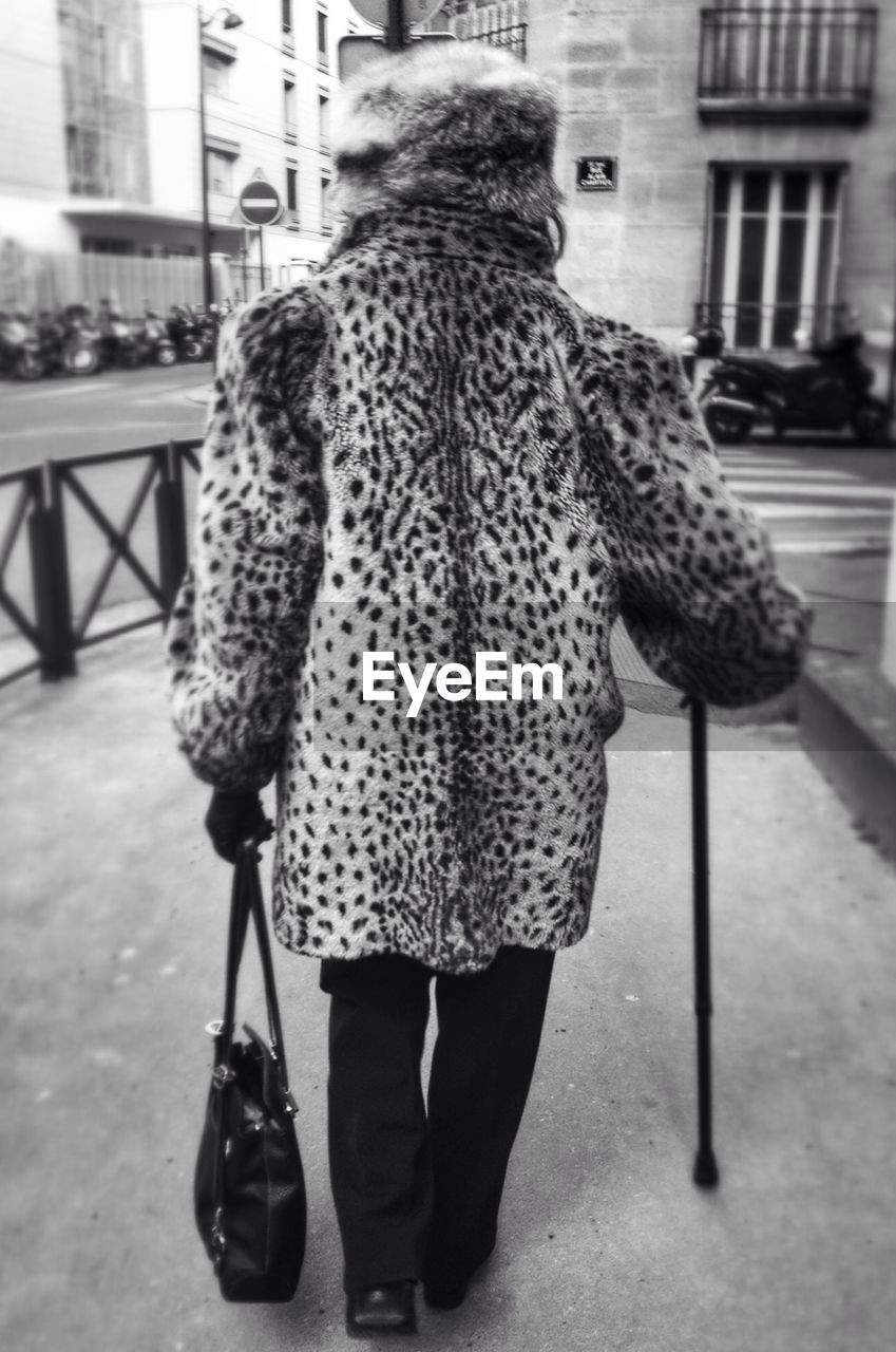 WOMAN STANDING ON PAVEMENT