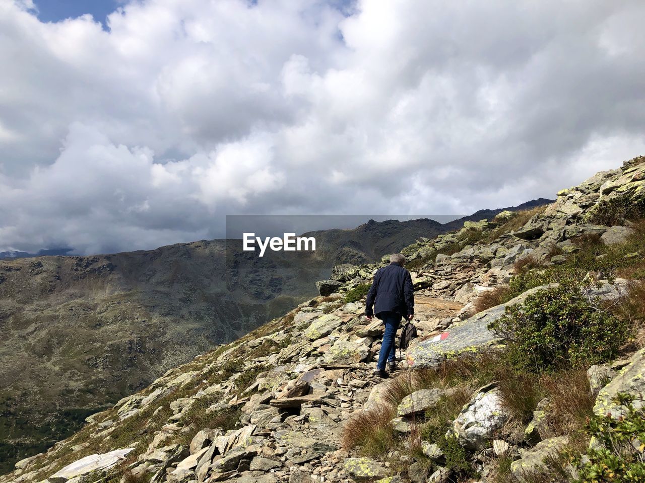 Rear view of men on mountain against sky