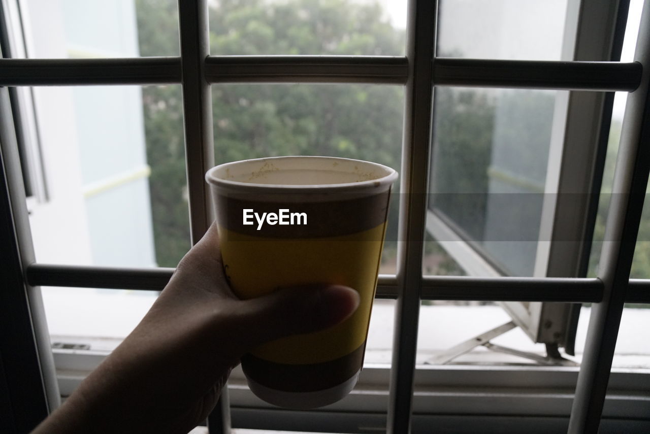 PERSON HOLDING COFFEE CUP