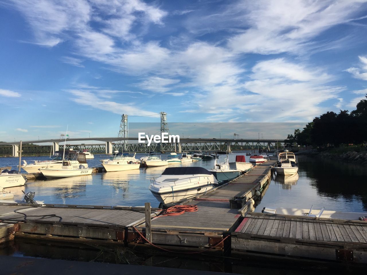 Boats moored at harbor against sky