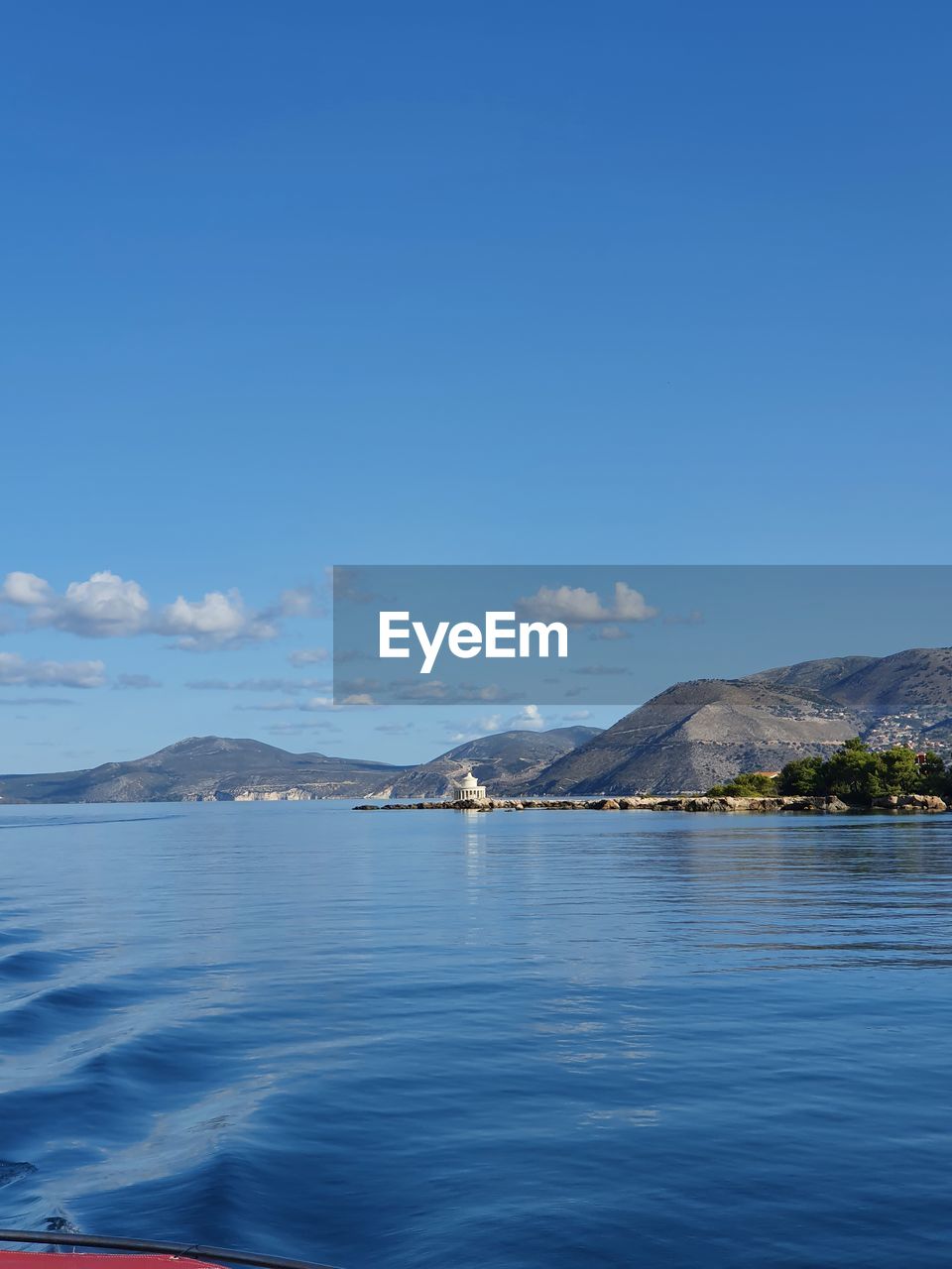 SCENIC VIEW OF SEA BY MOUNTAINS AGAINST BLUE SKY