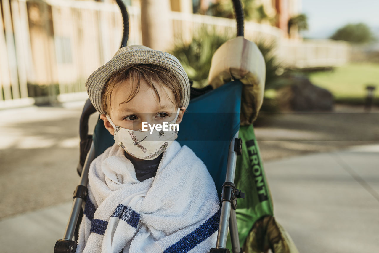 Close up portrait of young boy with mask on outside on vacation