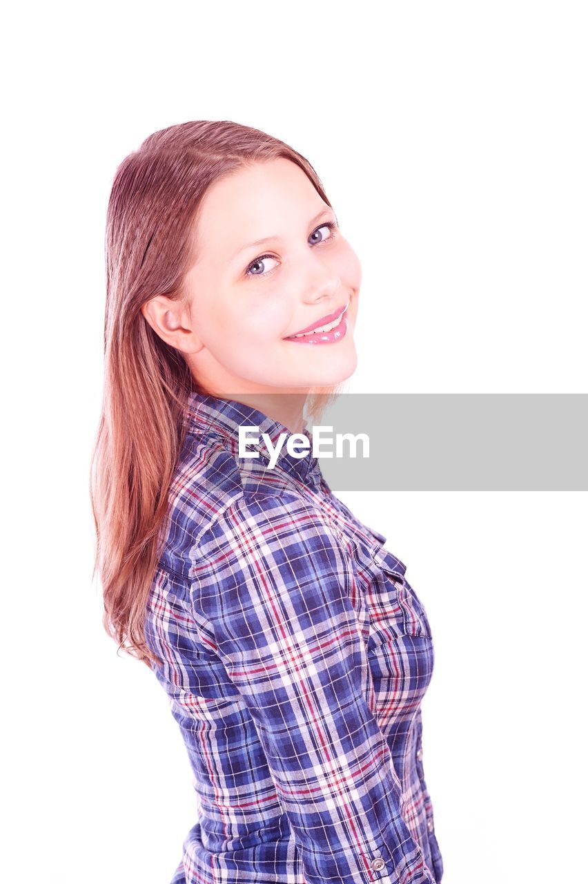 Portrait of smiling young woman standing against white background