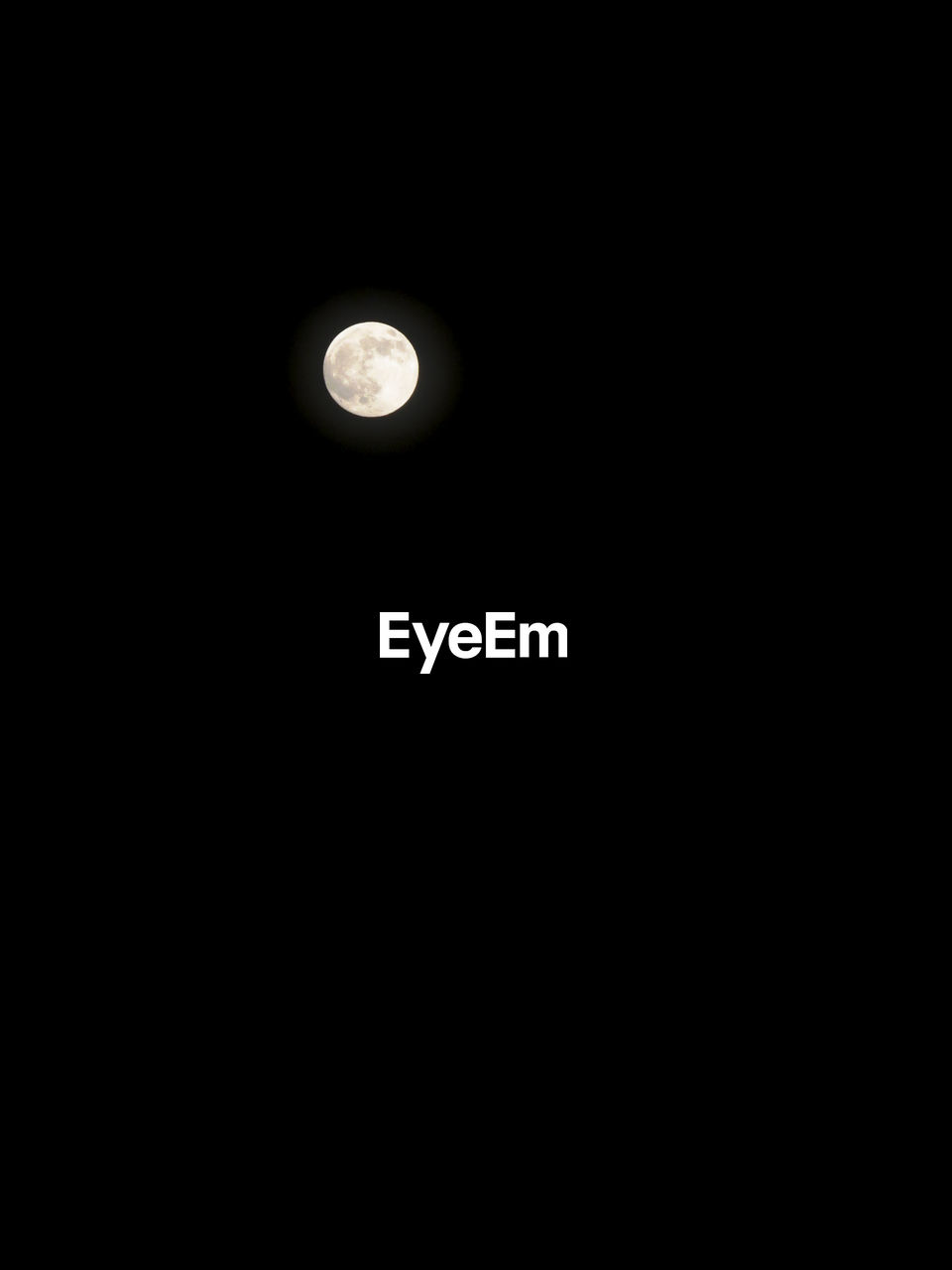 LOW ANGLE VIEW OF HALF MOON AGAINST DARK SKY