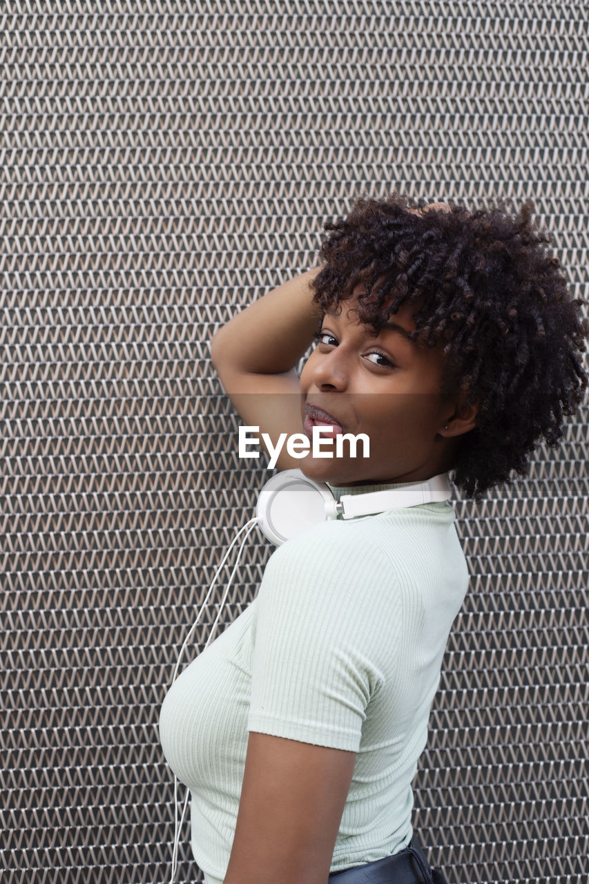 Portrait of a girl with afro hair with cheerful attitude in the urban background. 