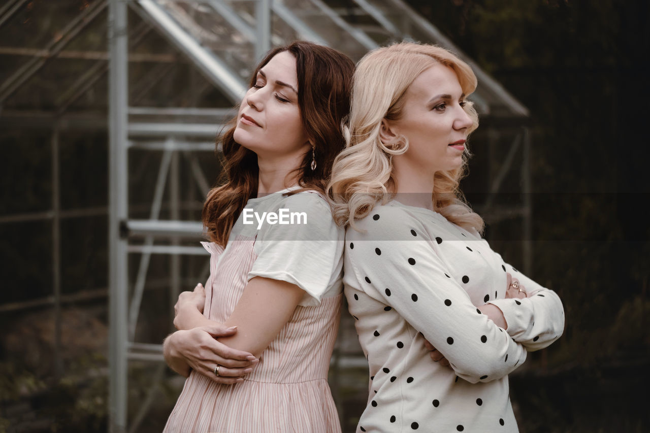 Two mature sisters in the garden in the evening. portrait of woman at her 40s and 30s, relatives