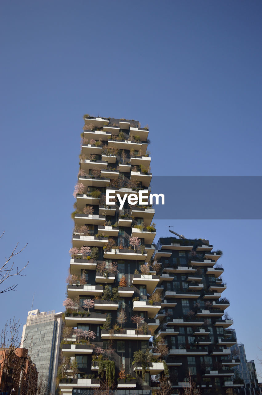 LOW ANGLE VIEW OF BUILDINGS AGAINST CLEAR BLUE SKY