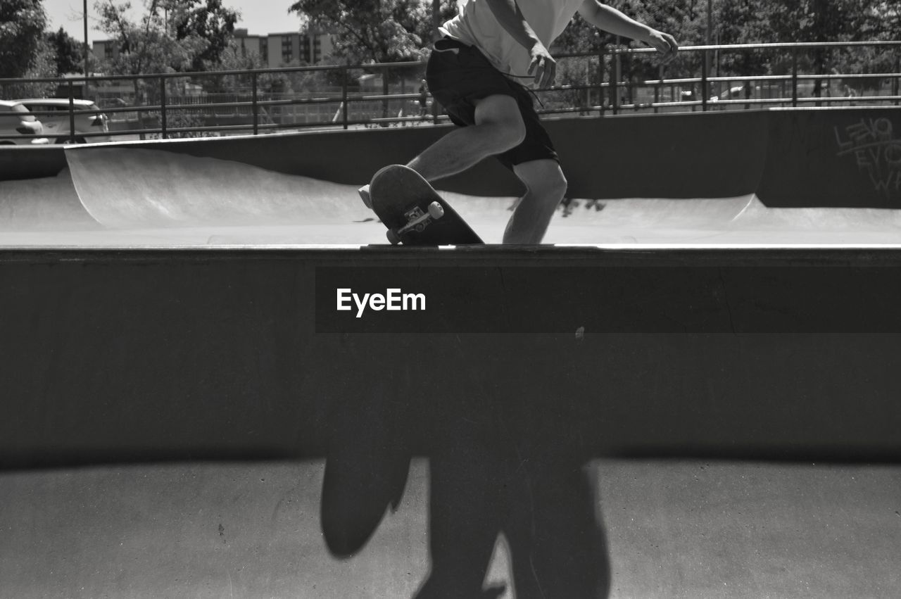 Low section of man skateboarding at skate park