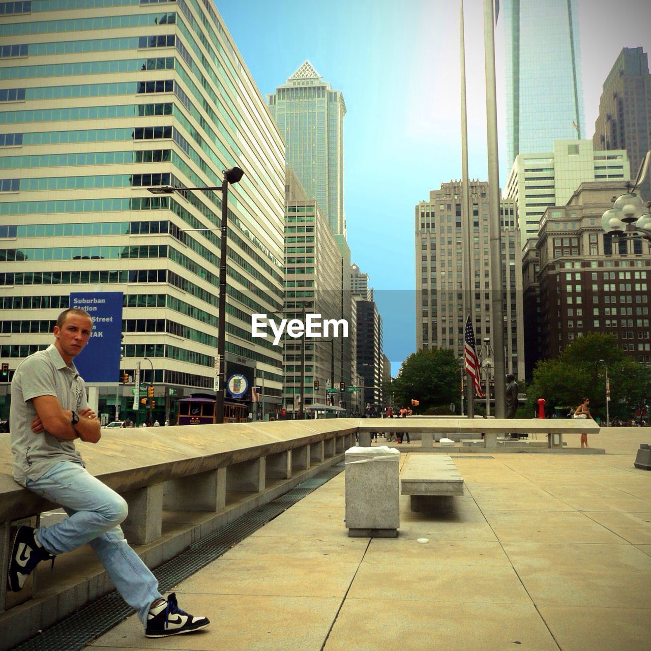 Portrait of man leaning on railing at walkway in city