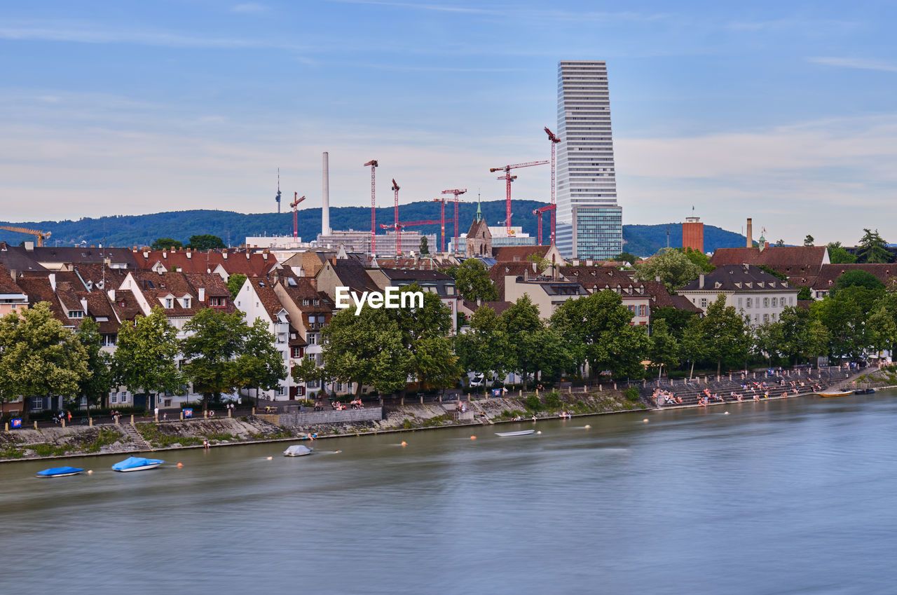 Scenic view of river by buildings against sky