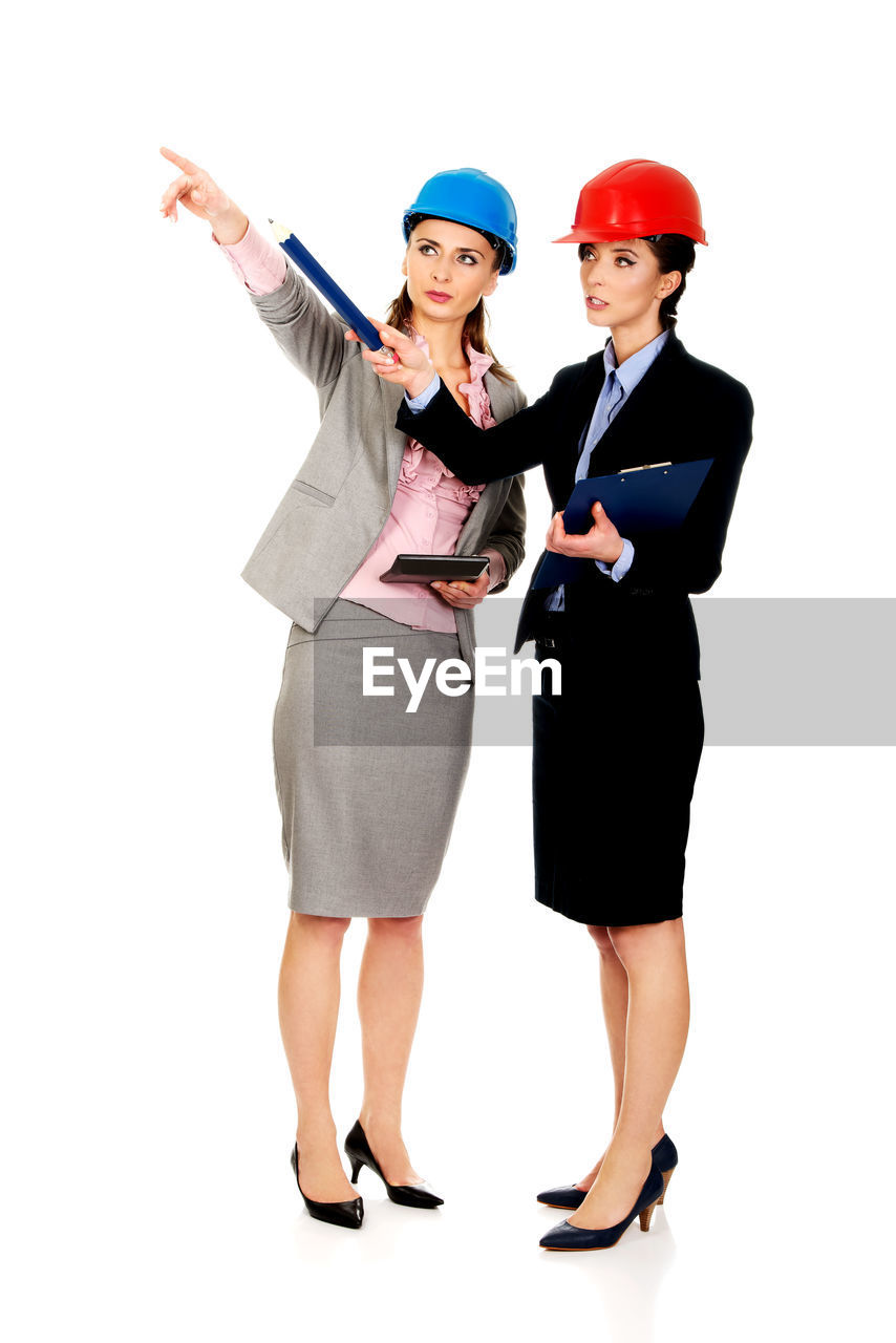 Female engineers pointing against white background