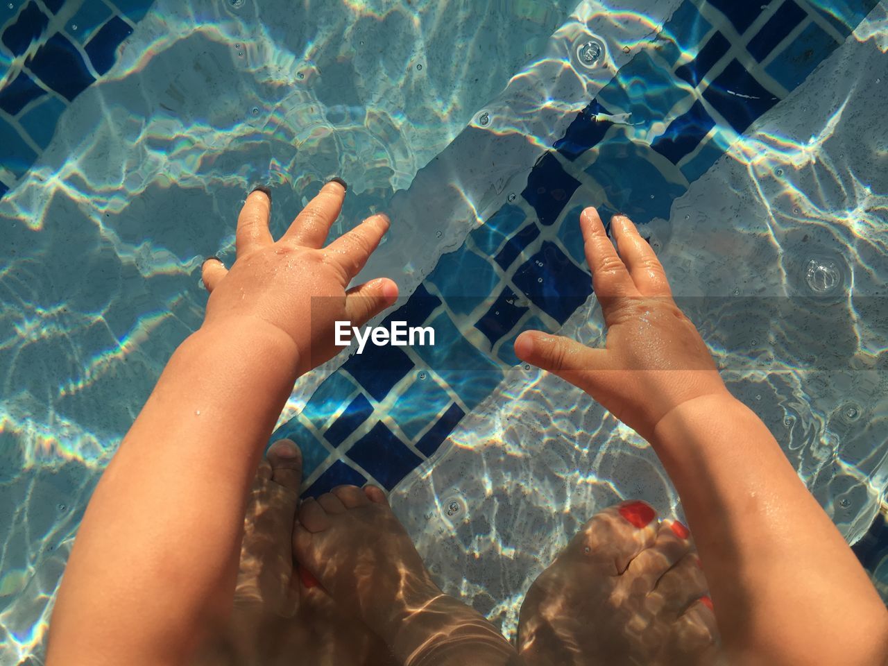 HIGH ANGLE VIEW OF WOMAN HAND IN POOL