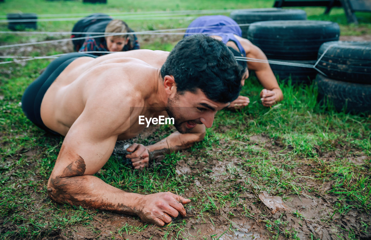 Friends crawling under strings on land