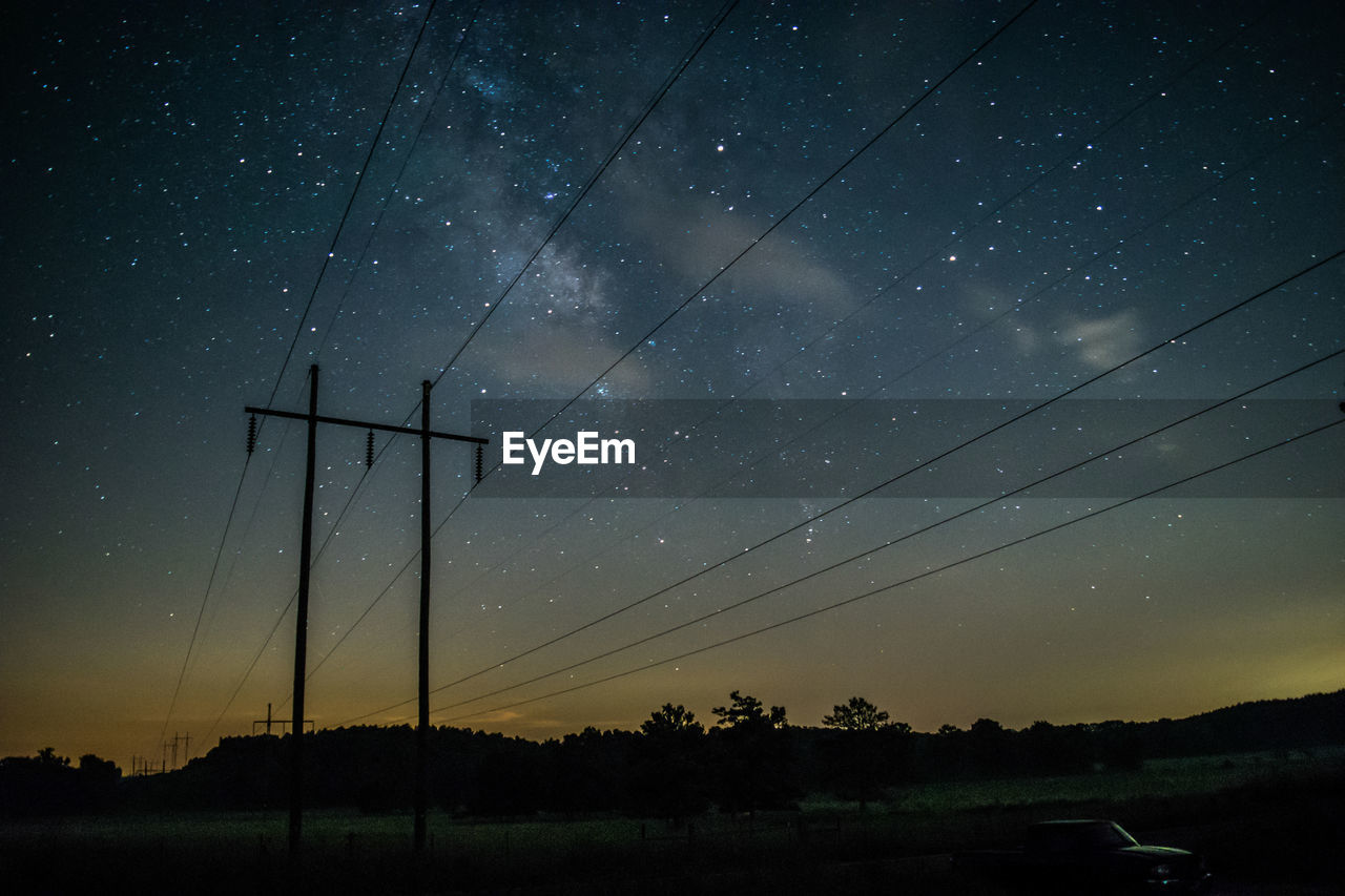 LOW ANGLE VIEW OF SILHOUETTE ELECTRICITY PYLONS AGAINST SKY AT NIGHT