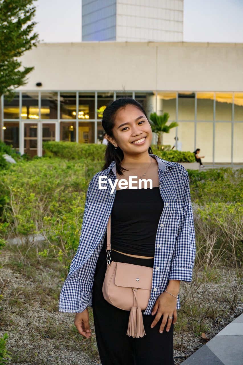 Portrait of a smiling young woman standing outdoors