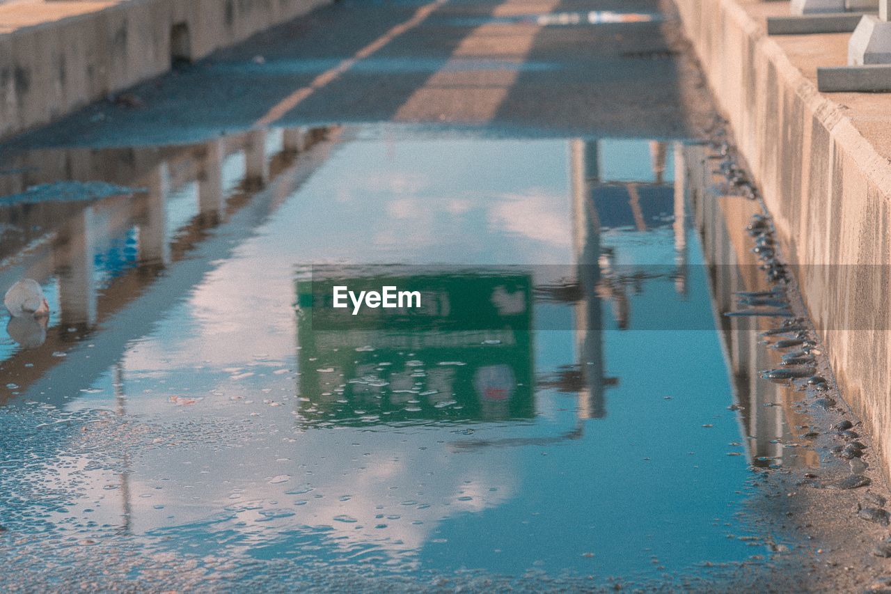 Reflection of building in puddle on street