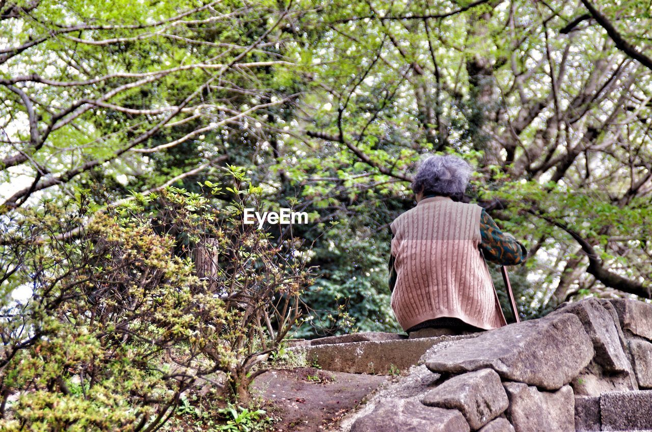 Low angle view of old women sitting on stone wall