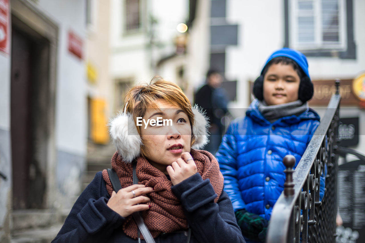 Woman with son looking away in city