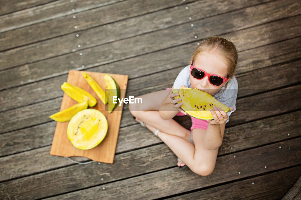 low angle view of young woman wearing sunglasses on table