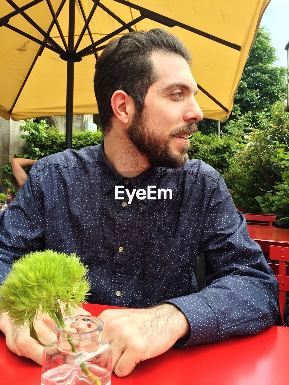 Young man looking away while sitting at table
