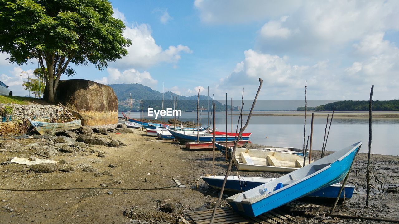 Boats moored at beach against sky