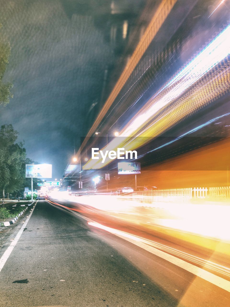 LIGHT TRAILS ON STREET AT NIGHT
