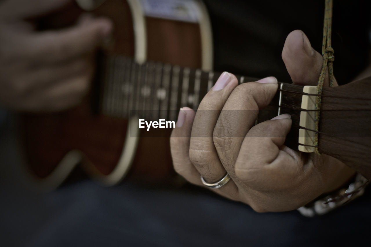 Close-up of hands playing guitar