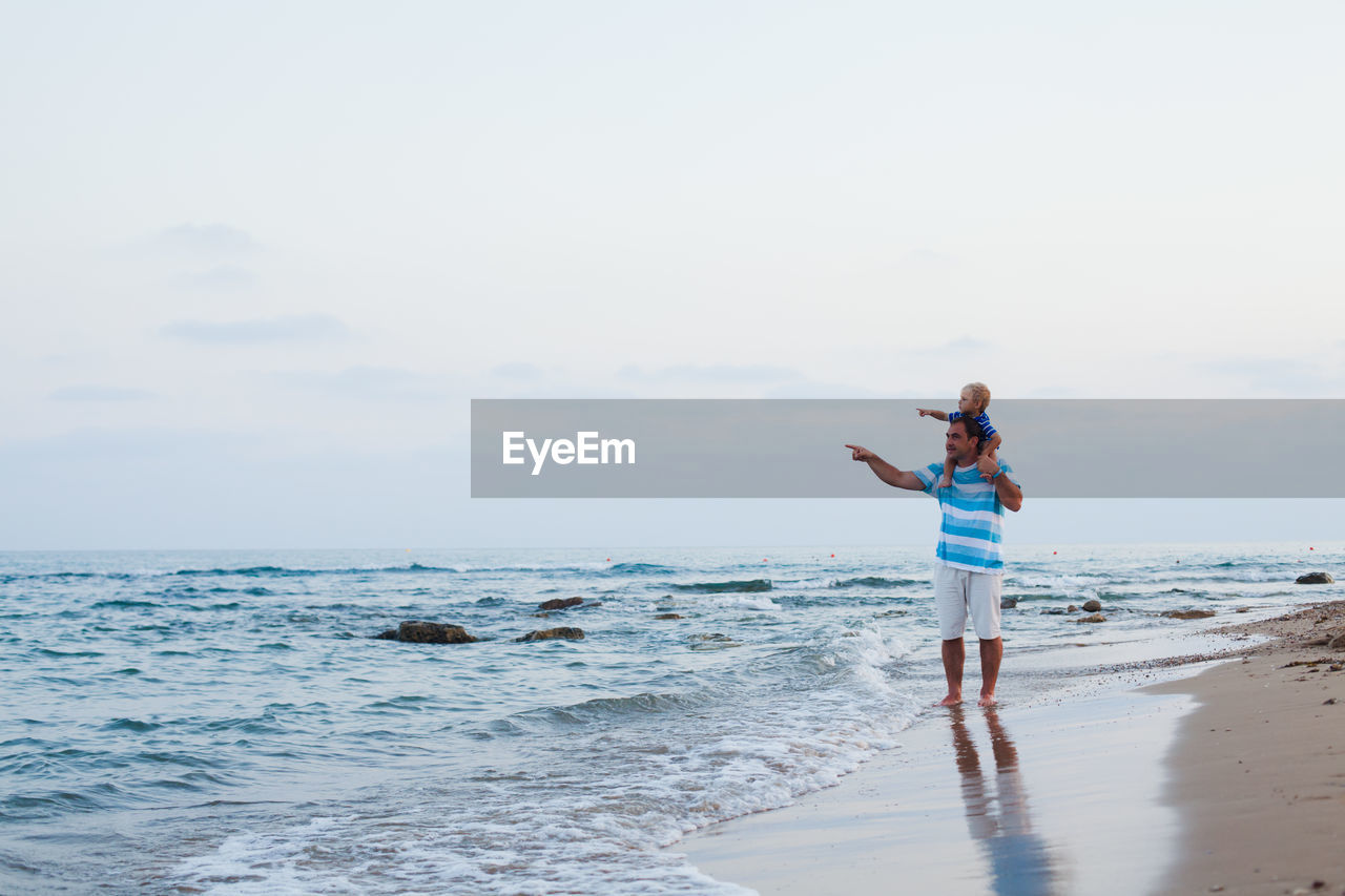 Man standing on beach against sky