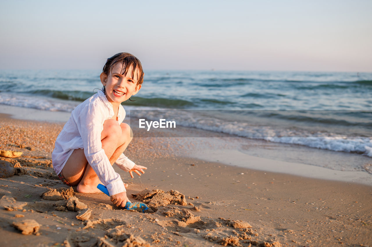 Full length of boy on beach against sky