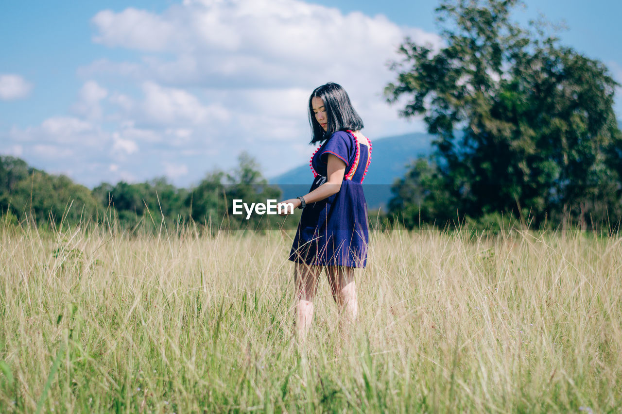 Young woman standing on grassy field