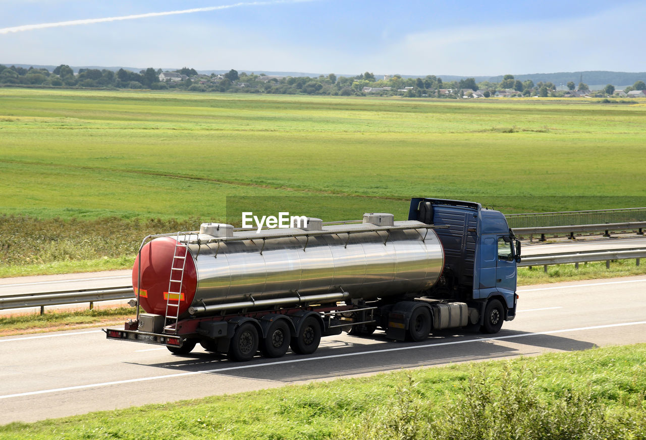 TRUCK ON ROAD AMIDST FIELD