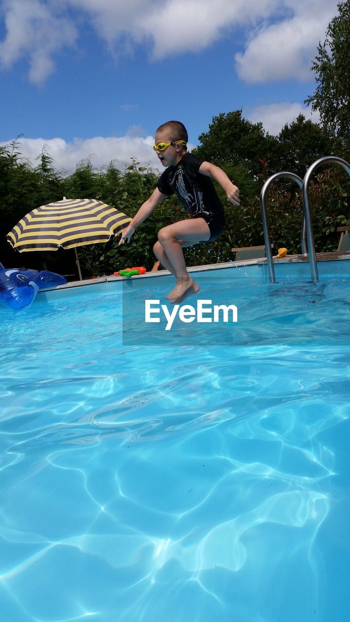 WOMAN JUMPING IN SWIMMING POOL