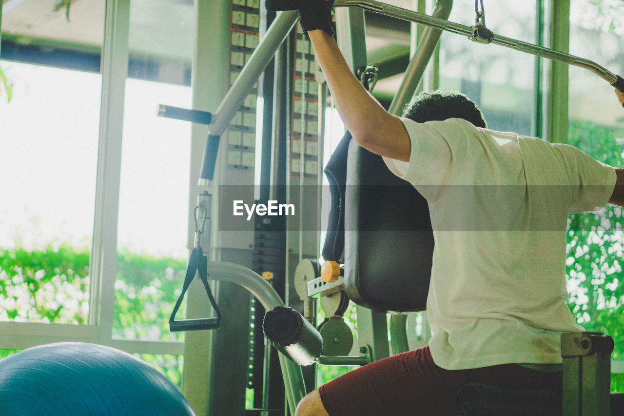 Rear view of man exercising at gym