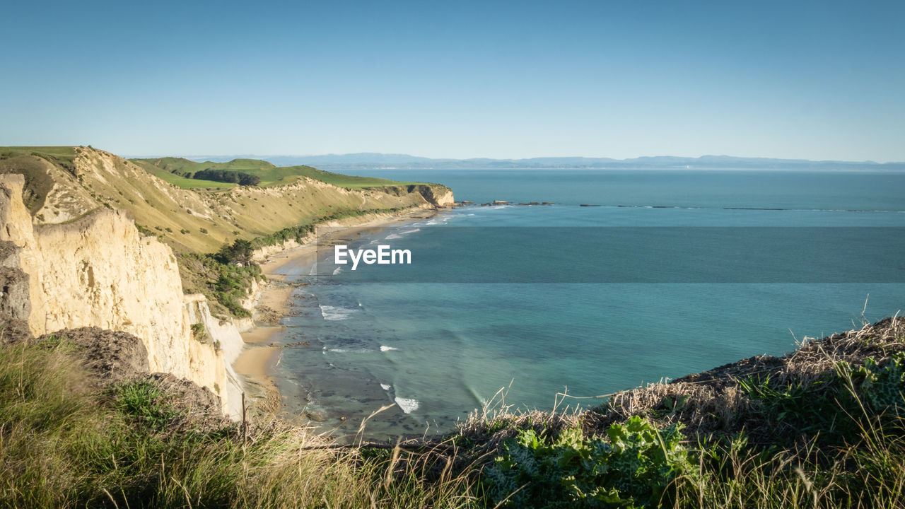 View on a rugged coast with cliffs and turquoise ocean waters, cape kidnappers, north, new zealand