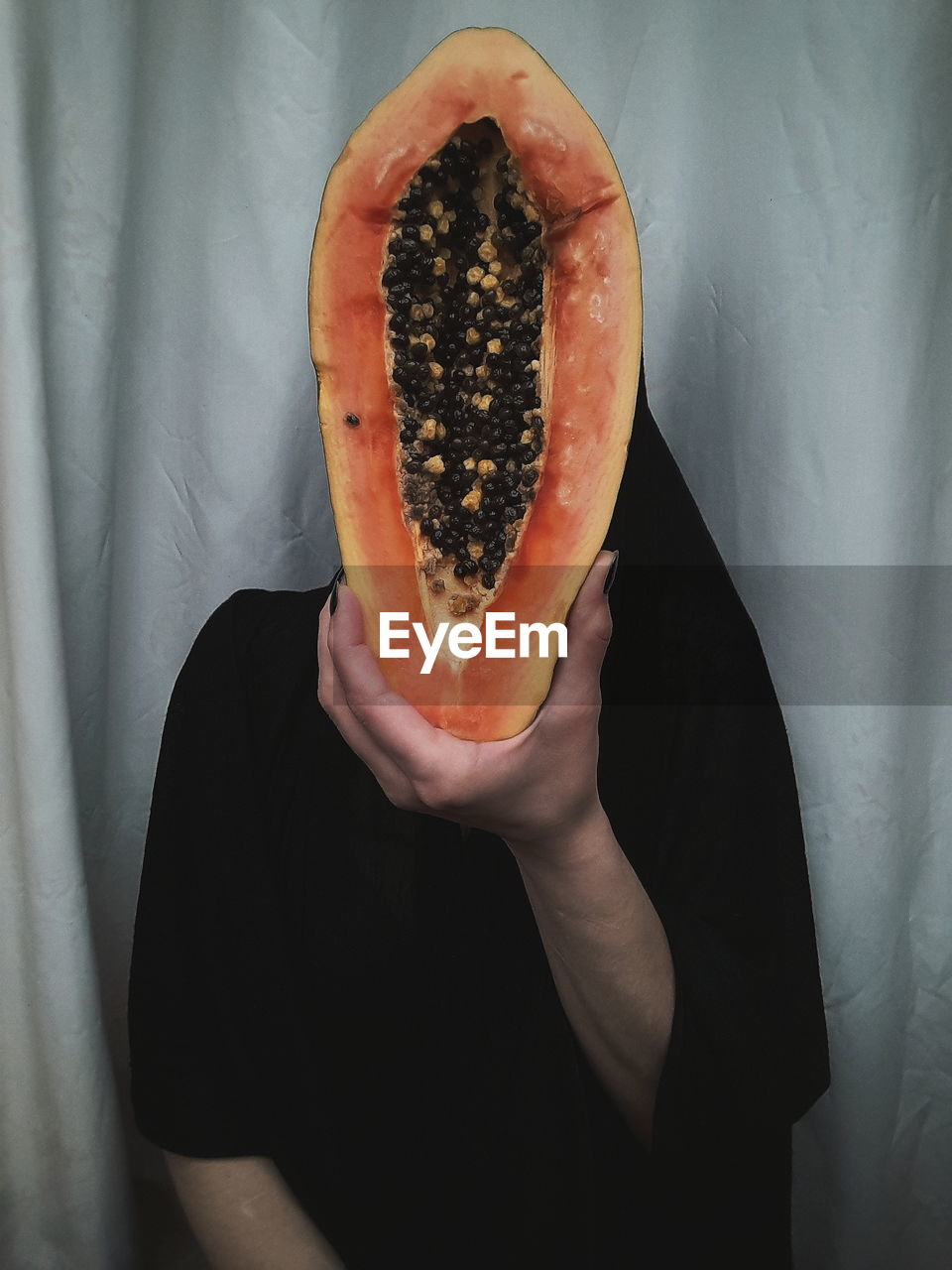 Midsection of man holding papaya