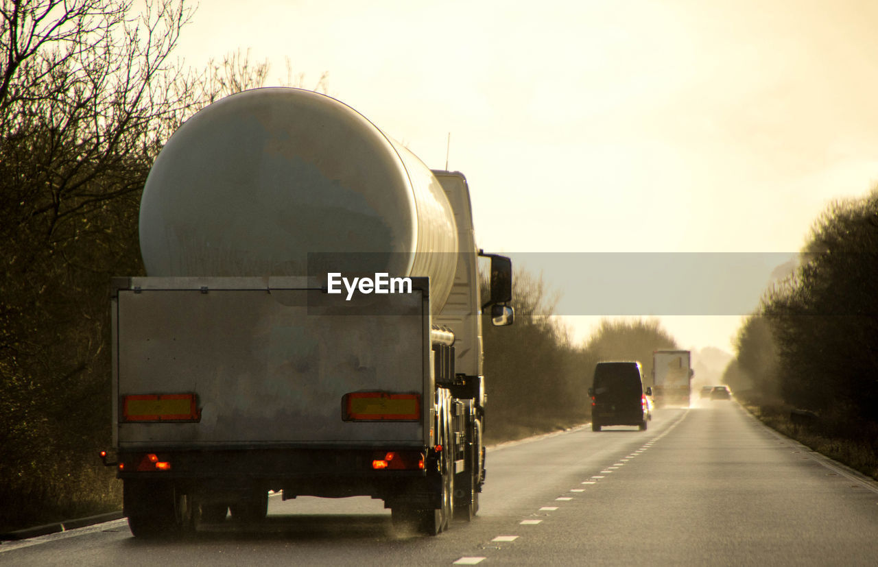 VEHICLES ON ROAD AGAINST SKY