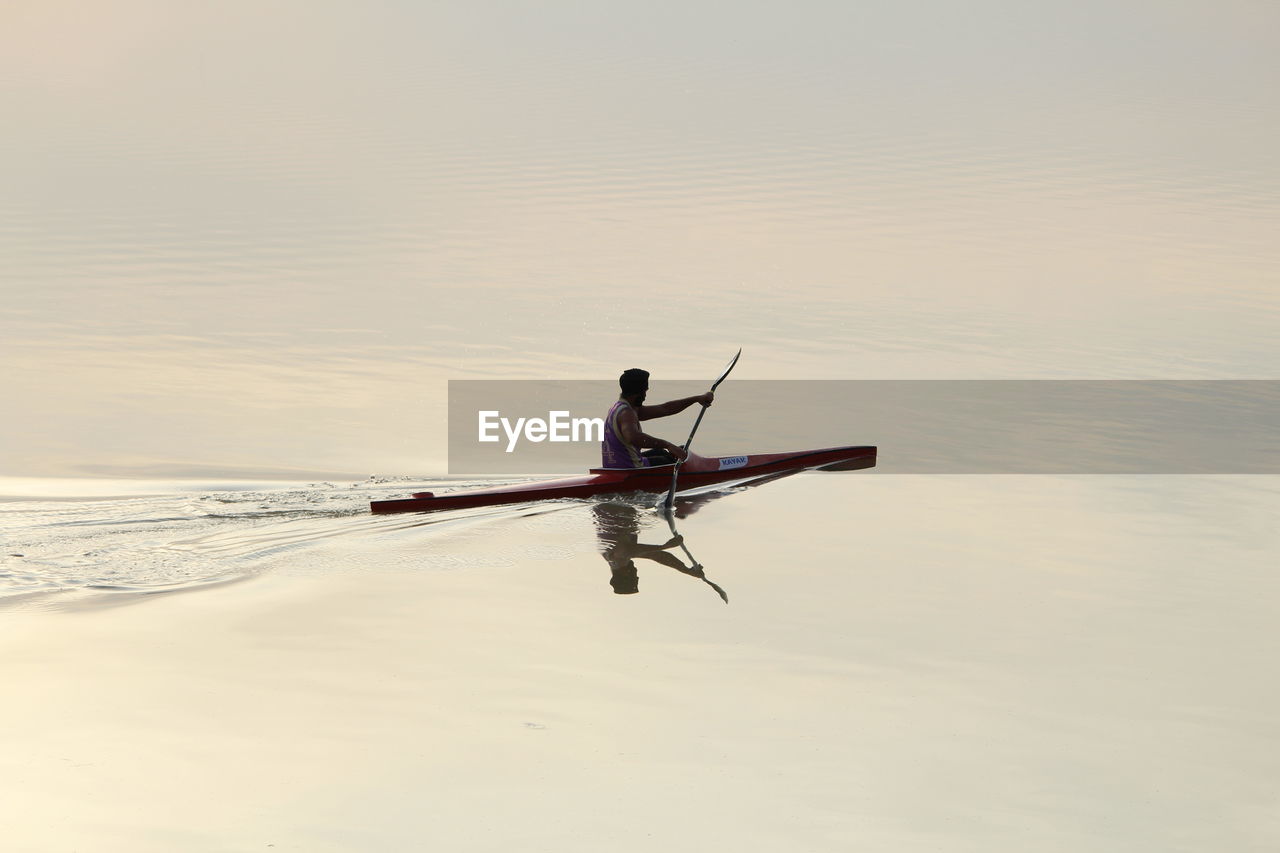 Side view of boating in calm lake