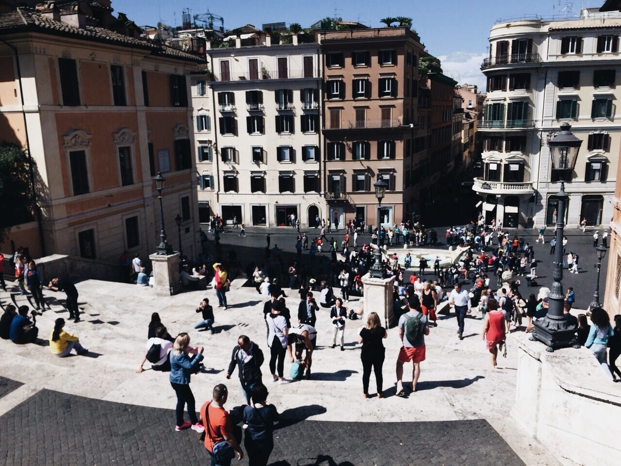 People in city by buildings against sky