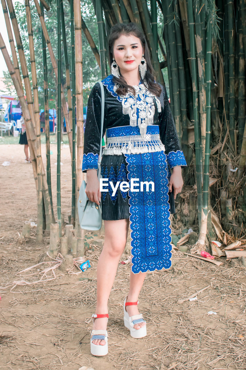 FULL LENGTH PORTRAIT OF HAPPY GIRL STANDING ON LAND